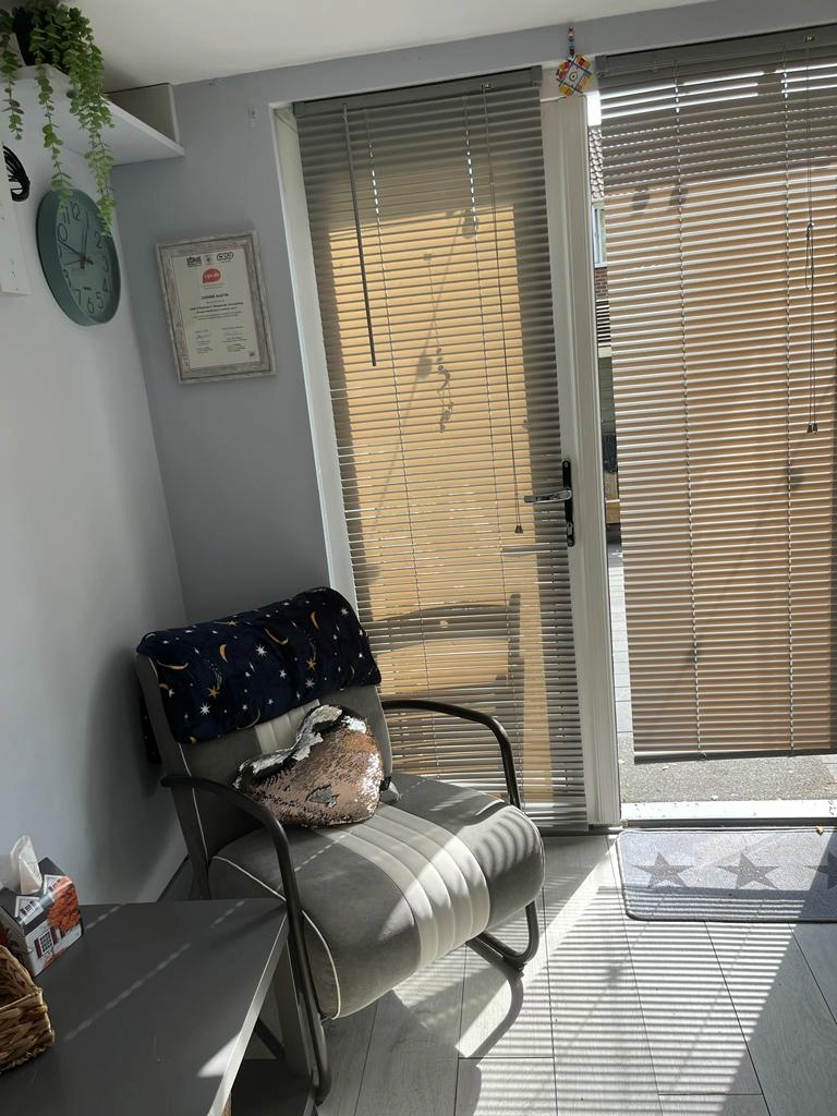 A room with a sofa, a chair and a lamp